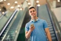 Handsome guy holding mobile phone and smiling Royalty Free Stock Photo