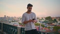 Handsome guy making call at evening cityscape. Athletic brunette waiting date Royalty Free Stock Photo