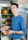 Handsome guy with meat near opened refrigerator Royalty Free Stock Photo