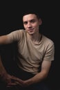 Handsome guy posing in studio on isolated black background. Studio portrait with one light source