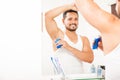 Handsome guy putting on some deodorant Royalty Free Stock Photo