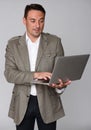 Handsome guy using laptop computer, standing. Royalty Free Stock Photo