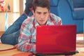 Handsome guy using laptop while lying on a floor Royalty Free Stock Photo