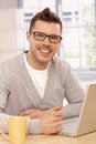 Handsome guy using laptop smiling Royalty Free Stock Photo