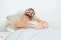 Handsome guy waking up and stretching in bed Royalty Free Stock Photo