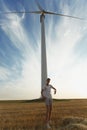 Handsome guy on a windmill background. Male teenager supporting alternative energy sources. Progressive youth concept. Royalty Free Stock Photo