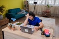 Handsome guy working online at call centre from home using the the laptop he type something and he wear the headset to Royalty Free Stock Photo