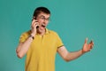 Handsome guy in a yellow casual t-shirt is posing over a blue background.