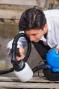 Handsome handyman holding in his hand the painting spray, construction worker painting with spray gun a wooden structure Royalty Free Stock Photo