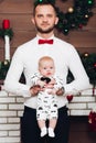 Handsome happy father in white shirt and tie holding little son by hands. Royalty Free Stock Photo