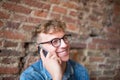 Young smiling hipster guy talking on portable mobile phone. Royalty Free Stock Photo