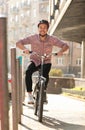 Handsome happy man in helmet riding bicycle on city street Royalty Free Stock Photo