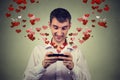 Handsome happy man sending receiving love sms text message on mobile phone Royalty Free Stock Photo