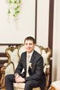 Handsome happy man sitting in luxury white chair Royalty Free Stock Photo