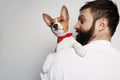Handsome happy man snuggling and hugging his basenji puppy dog, close friendship against a white background. Royalty Free Stock Photo