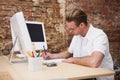 Handsome happy man using computer taking notes Royalty Free Stock Photo