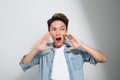 Handsome happy man wearing jeans T-shirt, guy speaking loudly, on white background