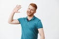 Handsome happy redhead man waiting for high five, smiling broadly raising palm high to greet person in modern way