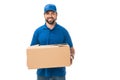 handsome happy young delivery man holding cardboard box and smiling at camera Royalty Free Stock Photo