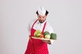 Handsome Head cook is Holding a Wicker Tray with Vegetables