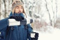 Handsome hiker man in warm clothes pours tea in mug from thermos in winter forest. Season concept. Selective focus