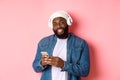 Handsome hipster guy in headphones smiling satisfied at camera, listening music in headphones, using mobile app Royalty Free Stock Photo