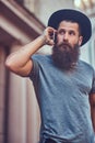 A handsome hipster male with a stylish beard and tattoo on his a