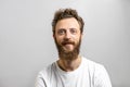 Handsome hipster man with beard smiling at camera over white background. Royalty Free Stock Photo