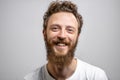 Handsome hipster man with beard smiling at camera over white background.