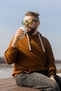 Stylish handsome hipster man holding drinks cocktail, spring time Royalty Free Stock Photo