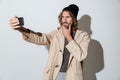 Handsome hipster man looking aside make selfie by phone