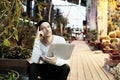 Handsome hipster man portrait working on portable laptop computer. Guy in black hat smiling in a park sunny day. Business lifestyl Royalty Free Stock Photo