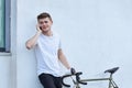 Handsome hipster man posing with bicycle in the city.