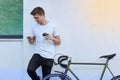 Handsome hipster man posing with bicycle in the city.