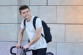 Handsome hipster man posing with bicycle in the city.