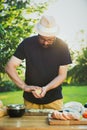 Handsome hipster man preparing meat and zucchini burgers, bbq summer garden food Royalty Free Stock Photo