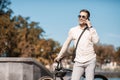 Handsome hipster at park. Businessman with bicycle speaks on phone Royalty Free Stock Photo