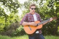 Handsome hipster playing the guitar Royalty Free Stock Photo