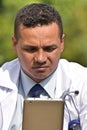 Unsure Male Doctor Using Tablet