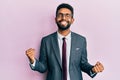 Handsome hispanic business man with beard wearing business suit and tie very happy and excited doing winner gesture with arms Royalty Free Stock Photo