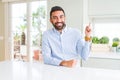 Handsome hispanic business man with a big smile on face, pointing with hand and finger to the side looking at the camera Royalty Free Stock Photo