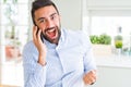 Handsome hispanic business man having a conversation talking on smartphone screaming proud and celebrating victory and success Royalty Free Stock Photo