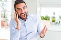 Handsome hispanic business man having a conversation talking on smartphone very happy and excited, winner expression celebrating Royalty Free Stock Photo