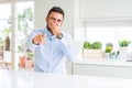 Handsome hispanic business man Laughing of you, pointing to the camera with finger hand over mouth, shame expression Royalty Free Stock Photo