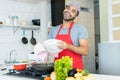 Handsome hispanic kitchen assistant cleaning plates at work