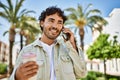 Handsome hispanic man with beard smiling happy outdoors on a sunny day having a conversation speaking on the phone Royalty Free Stock Photo