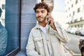 Handsome hispanic man with beard smiling happy outdoors on a sunny day having a conversation speaking on the phone Royalty Free Stock Photo