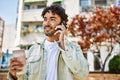 Handsome hispanic man with beard smiling happy outdoors on a sunny day having a conversation speaking on the phone Royalty Free Stock Photo