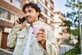 Handsome hispanic man with beard smiling happy outdoors on a sunny day having a conversation speaking on the phone Royalty Free Stock Photo