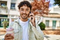 Handsome hispanic man with beard smiling happy outdoors on a sunny day having a conversation speaking on the phone Royalty Free Stock Photo